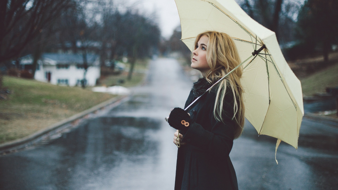 فتاة تحت المطر مع مظلتها
